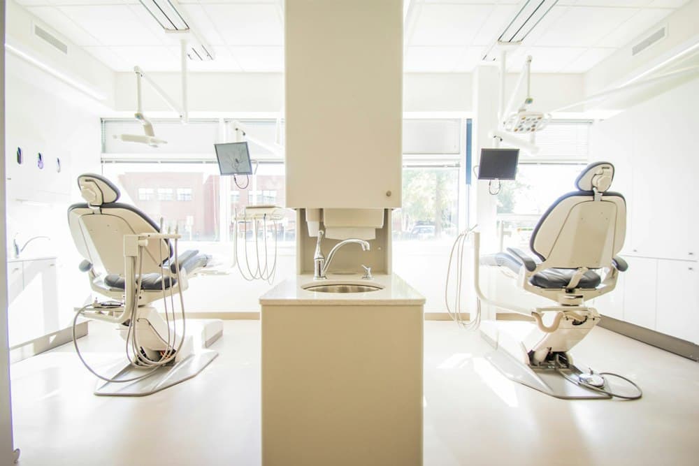 Bright, modern dental treatment room with two patient chairs